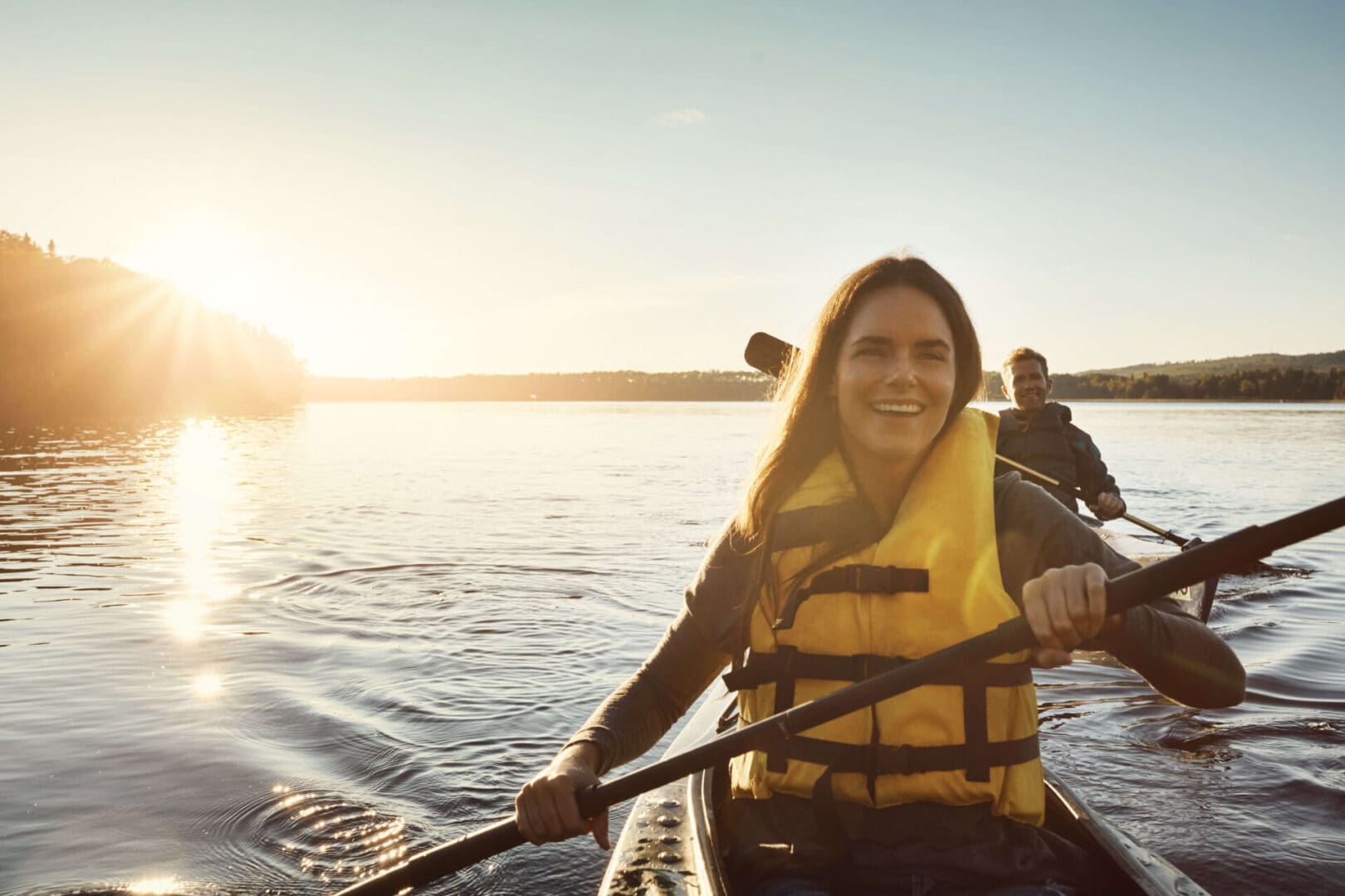 A woman is paddling in a canoe on the water.