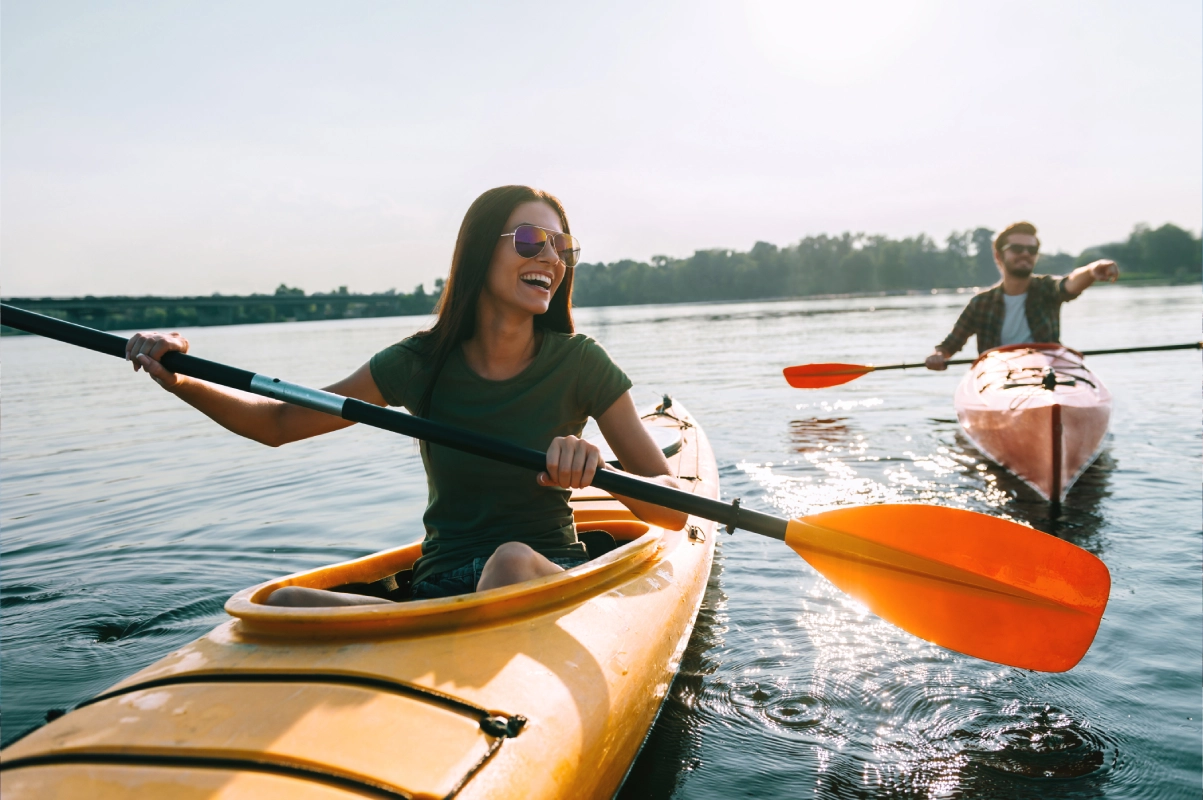 Two people in a yellow kayak with oars.