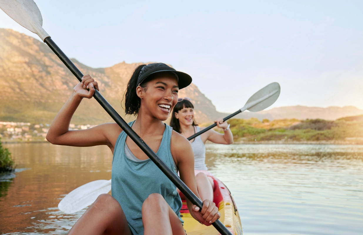 Two women are kayaking on a lake.