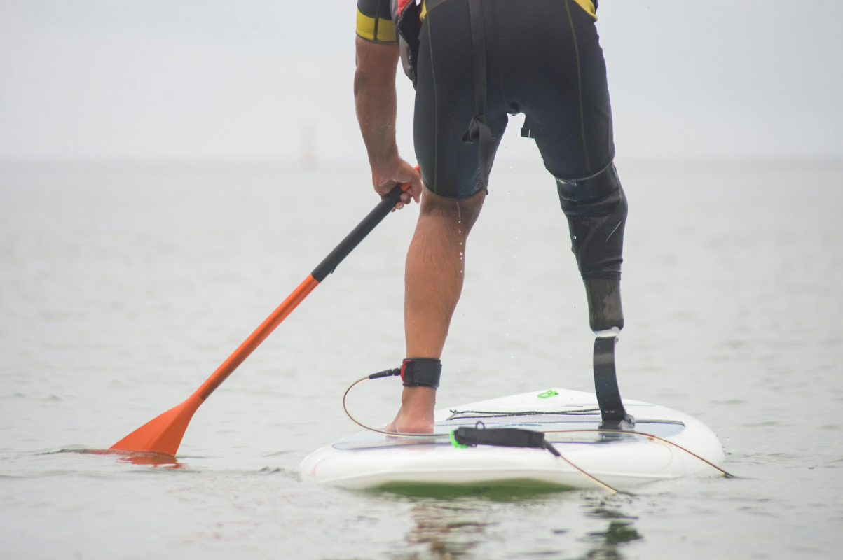 A man standing on top of a surfboard in the water.